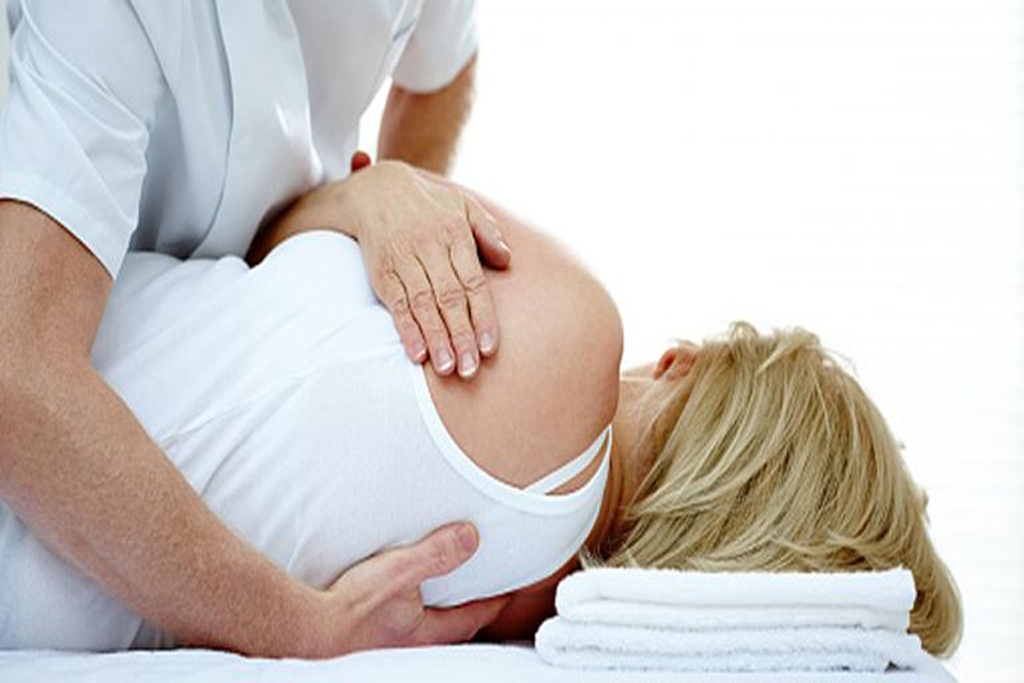 a pregnant woman being massaged with a laying down posture on one of her side 