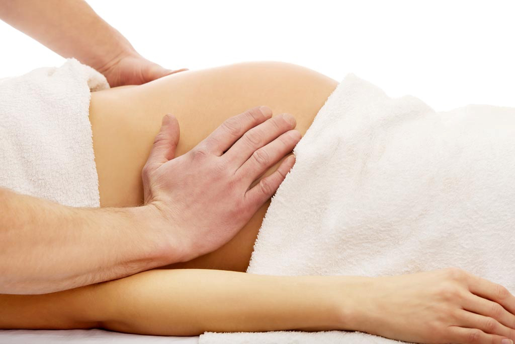 a pregnant women being massaged on her abdomen